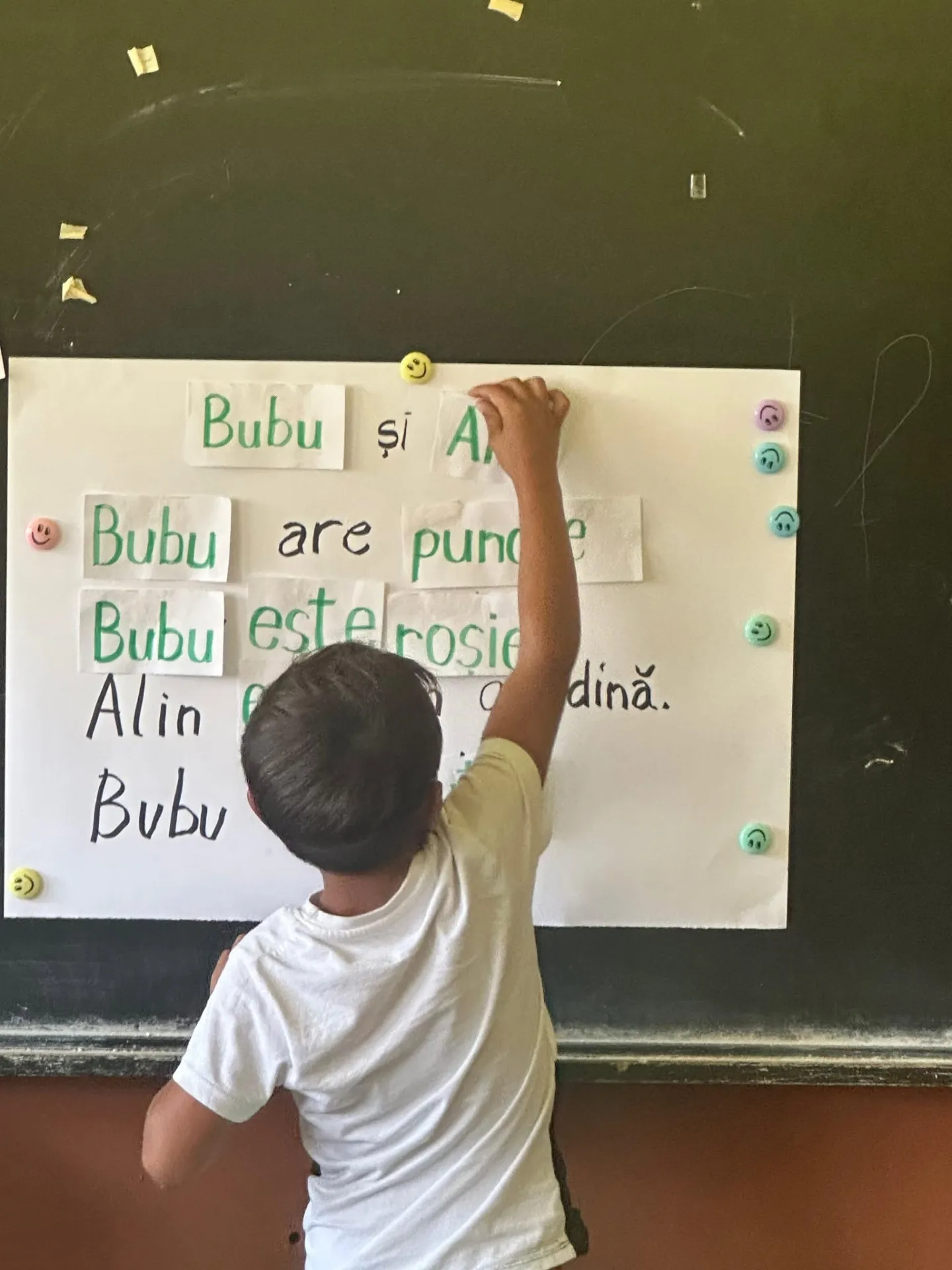 Băiat scriind la tablă la bootcampul de literație